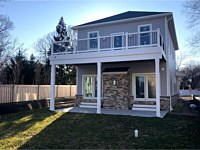 <b>Deck with White Washington Vinyl Railing-Black Aluminum Balusters-Deck Drain and gutters to keep the space below the deck dry in Arnold MD</b>